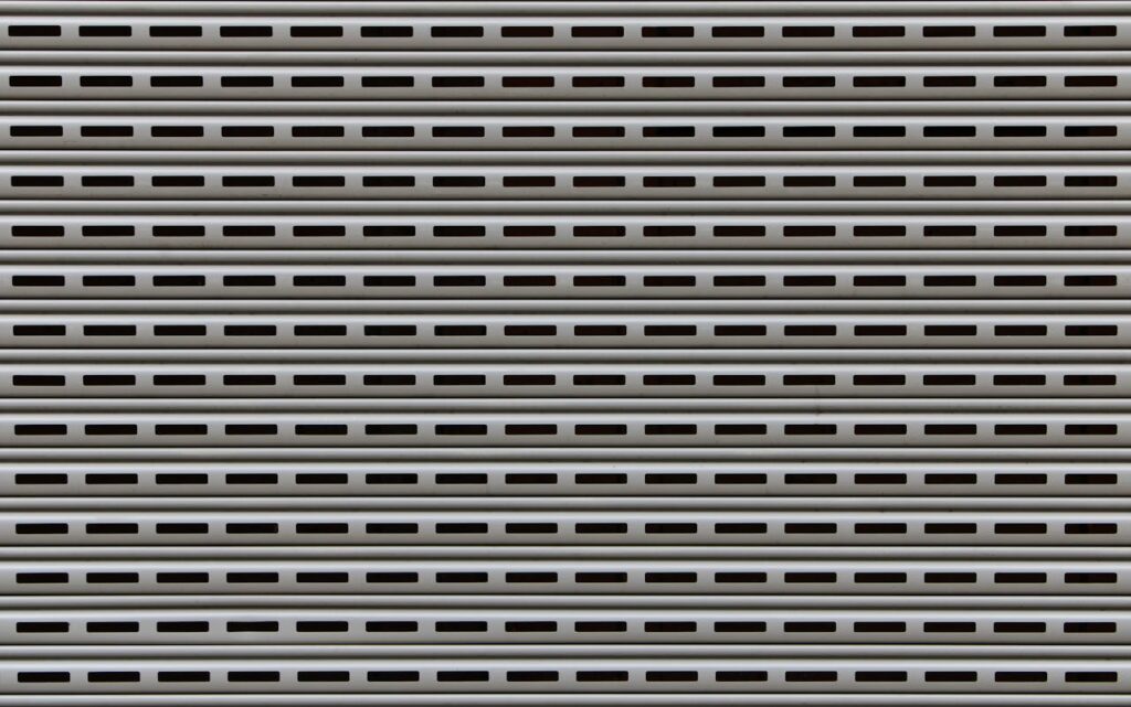 Close-up view of a textured metallic roll-up door showcasing repetitive horizontal patterns.